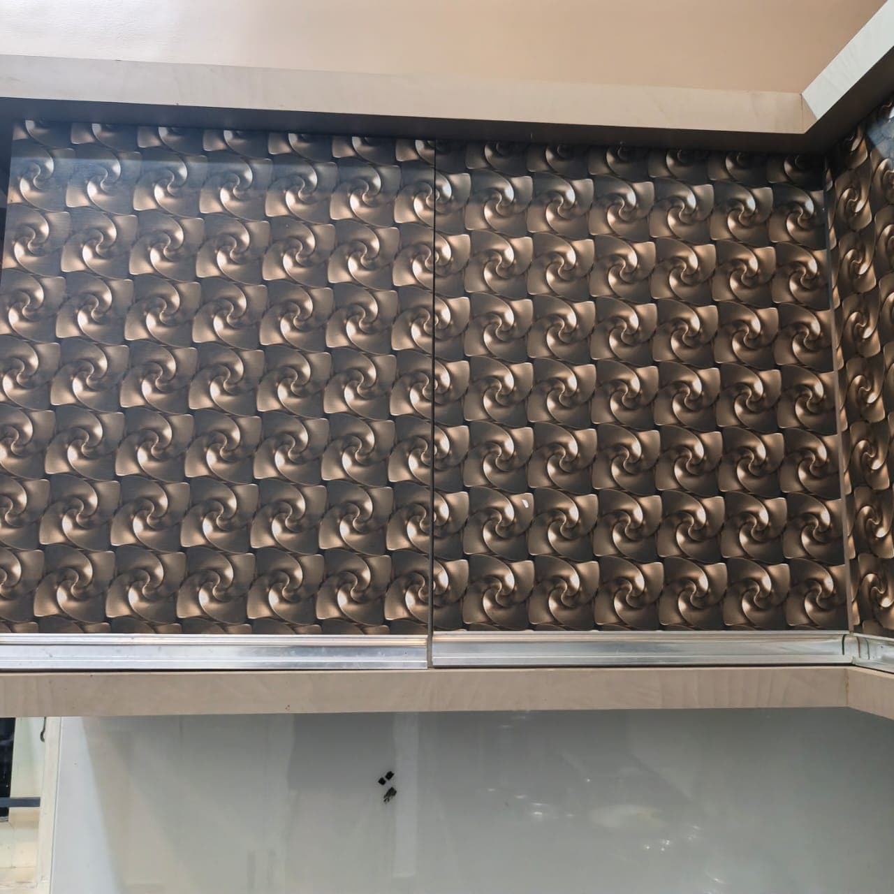 Overhead kitchen cabinets with bronze swirl 3D laminate shutters and aluminium bottom profile handles